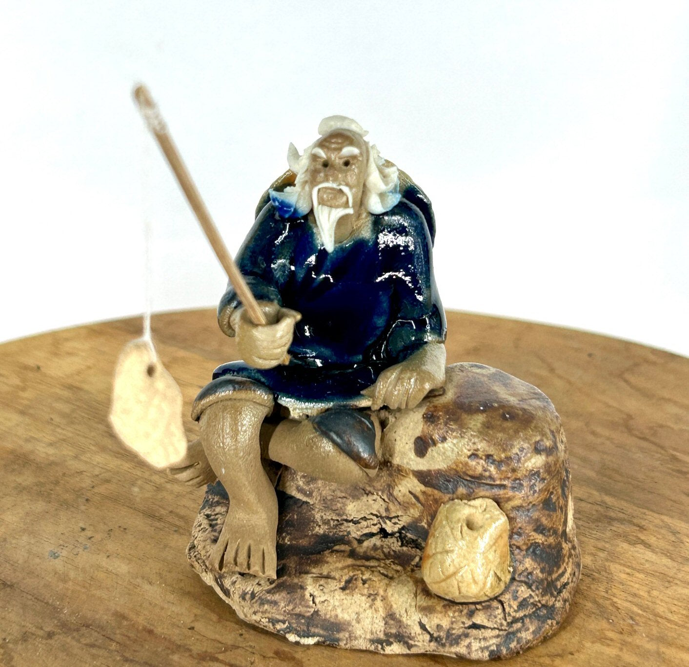 Miniature Ceramic Glazed Fisherman Figurine Sitting On A Log Blue - 2.5"