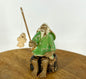 Miniature Ceramic Glazed Fisherman Figurine Sitting On A Log  Light Green - 2.5"